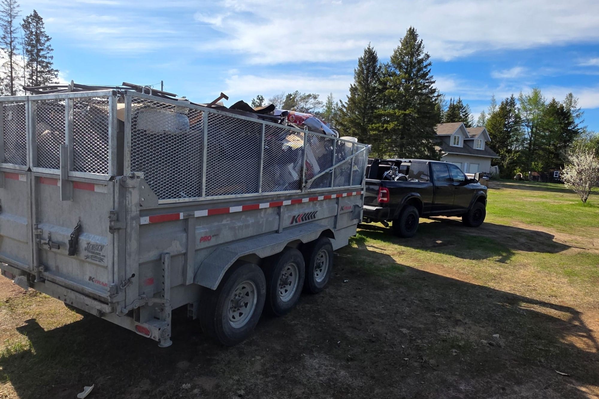 TCM Junk Removal dump trailer loaded with household junk and renovation debris at a Sudbury property